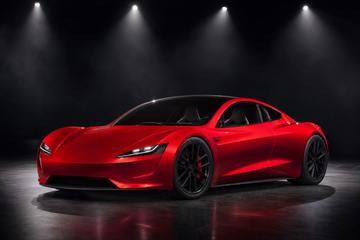 Red Tesla Roadster prototype on a dark stage under spotlights