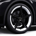 Close-up of a black car wheel with a white rim on a dark background