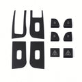Ten dark carbon-weave covers laid out on white, showing four panel surrounds and six smaller door-control covers.