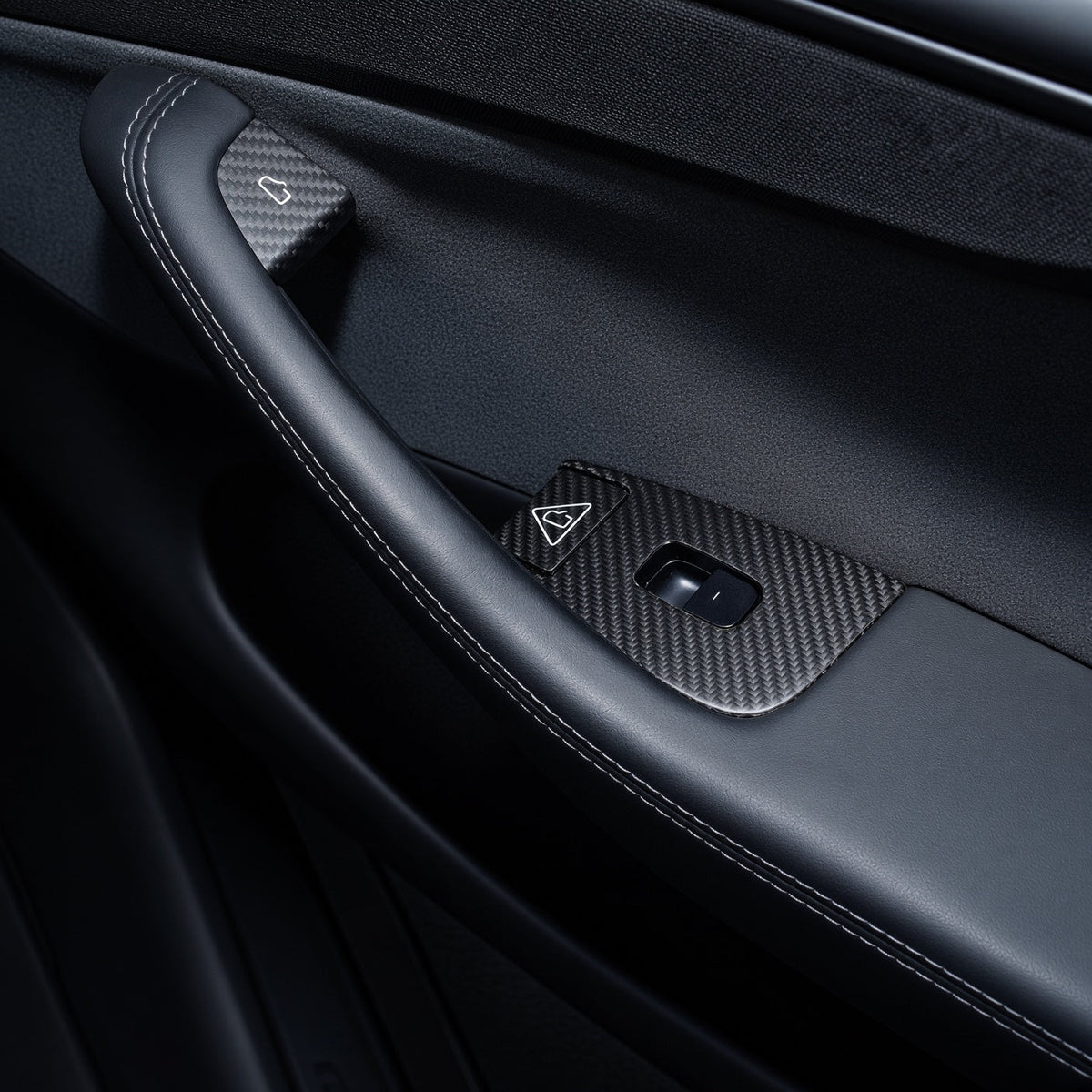 Single-window-switch door panel with carbon-weave covers around the switch and two door-release control areas.