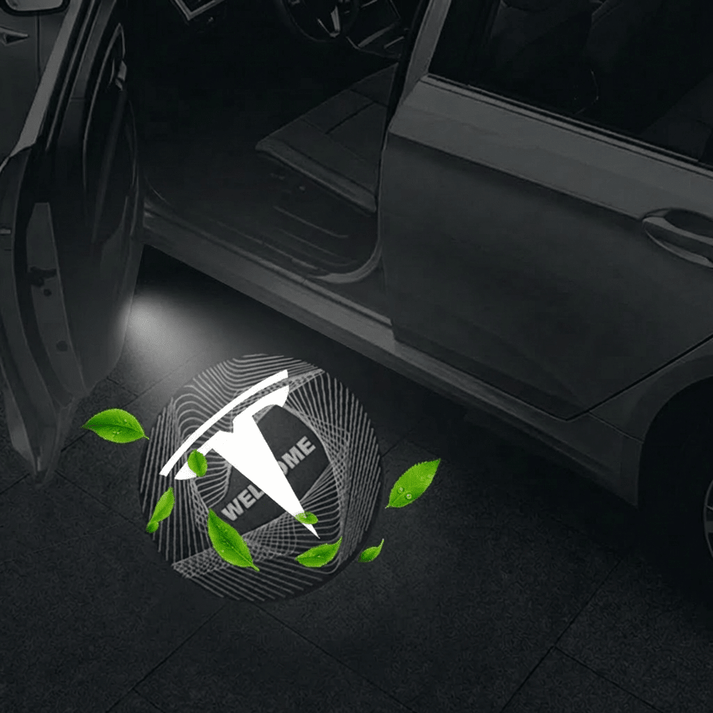 Tesla Model Y with a dynamic 3D T-logo projected on the ground from the open door.