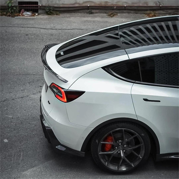 White pre-refresh Tesla Model Y with a dry carbon fiber rear spoiler installed
