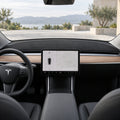 Black flannel front dashboard mat fitted in a legacy left-hand-drive Tesla Model 3 with the original wood dashboard trim.