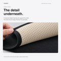 Close-up of the beige dotted fabric underside and black bound edge of one front dashboard mat.