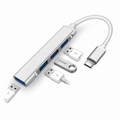 Silver four-port USB hub with a short USB-C cable, blue USB-A sockets and small connected-device examples on white.