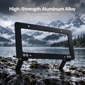 Black rectangular plate frame with two lower mounting legs standing on wet rocks.