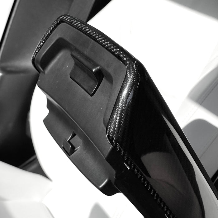 Underside view of the molded carbon fiber armrest cover showing the center-console release opening